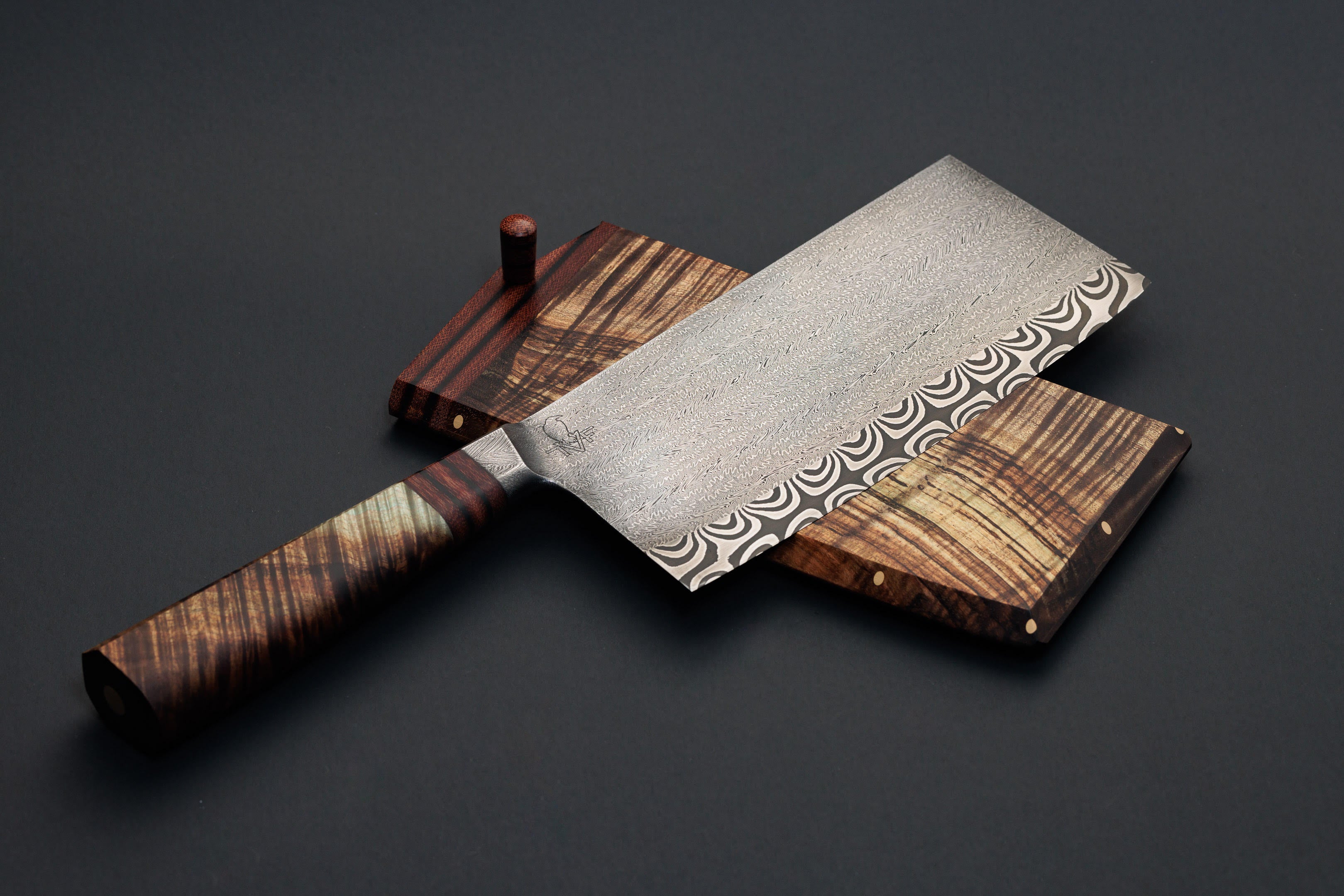 Integral bolster with mosaic damascus blade cleaver knife on black background