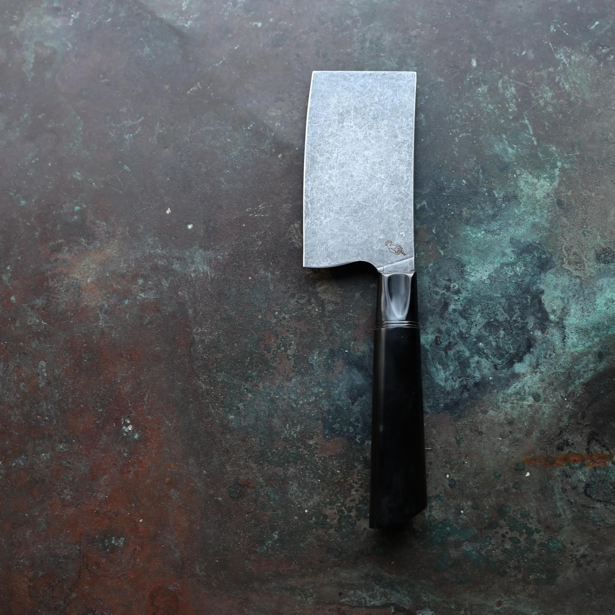 STONEWASH MINI CLEAVER OBSIDIAN KITCHEN KNIFE BLACK BOLSTER AND BLACK HANDLE ON CONCRETE BACKGROUND