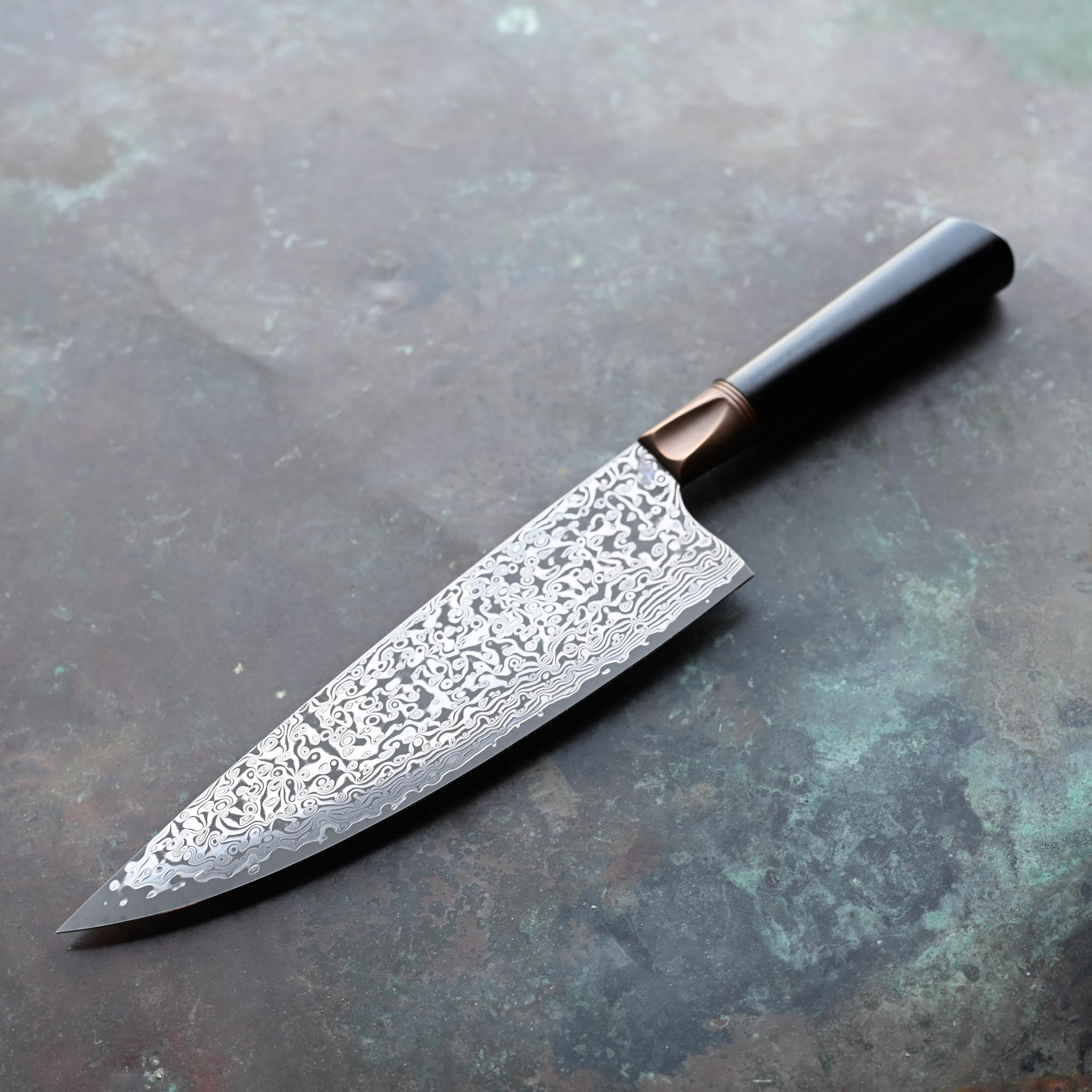 Damascus Steel Chef Knife with Antique Bolster and Black Handle on Concrete Background