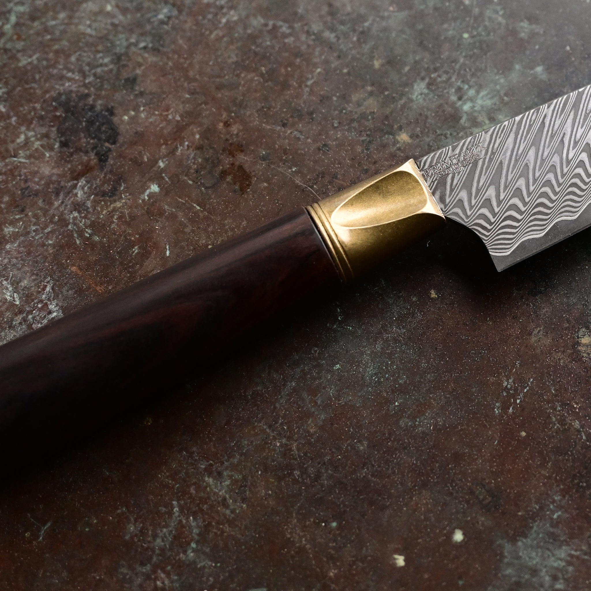 A one-of-a-kind 6.5" Meridian petty knife with a sawtooth Damascus blade, natural bronze bolster, and a straight-grained Turkish walnut handle in rich brown tones, hand-forged by John Phillips